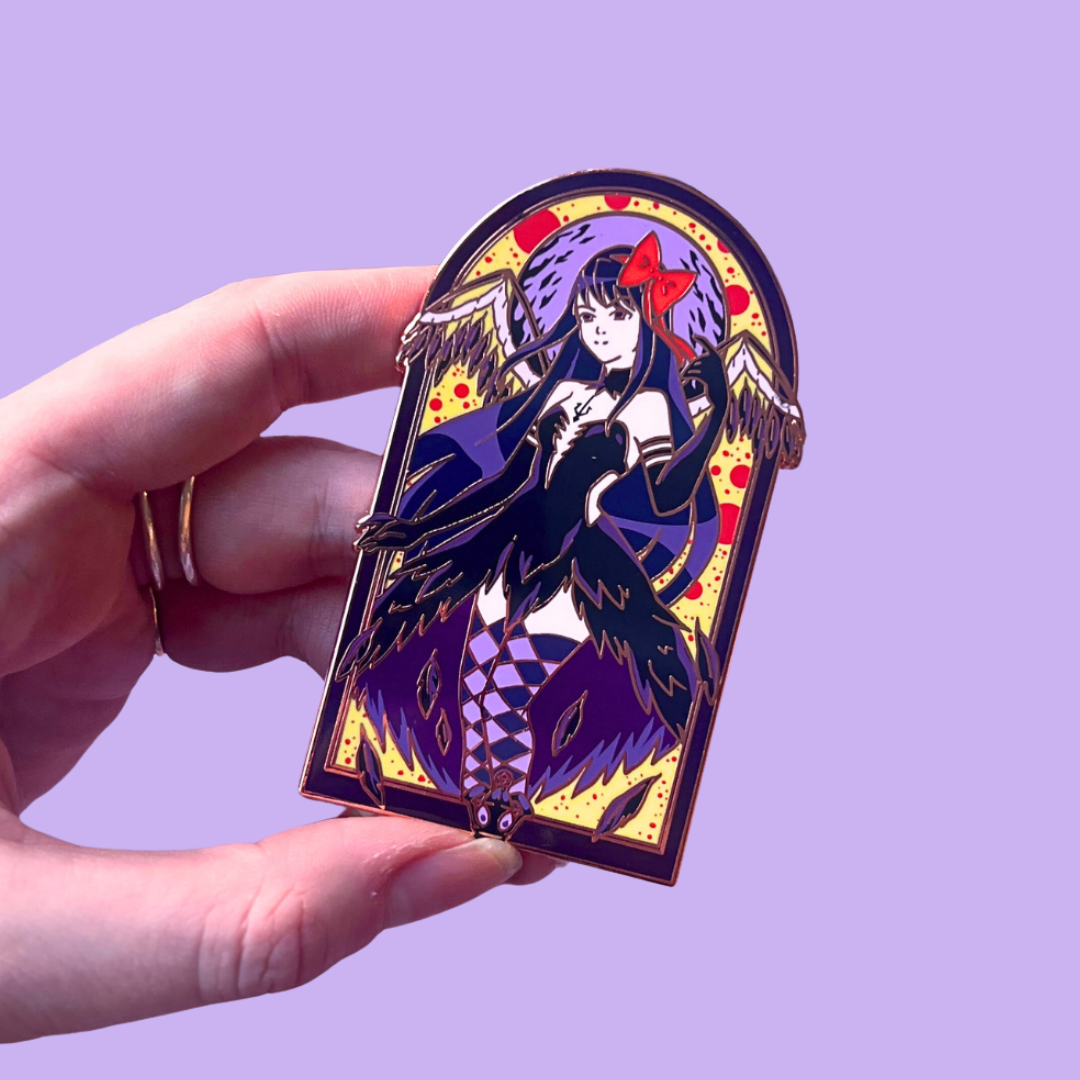 Decorative pin with a fantasy design held by a hand against a purple background