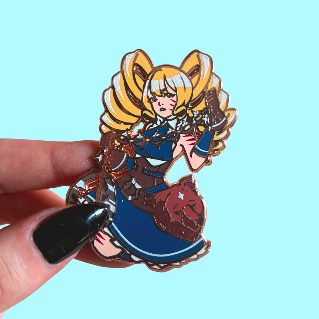 Enamel pin of a character with blonde hair and blue outfit against a light blue background