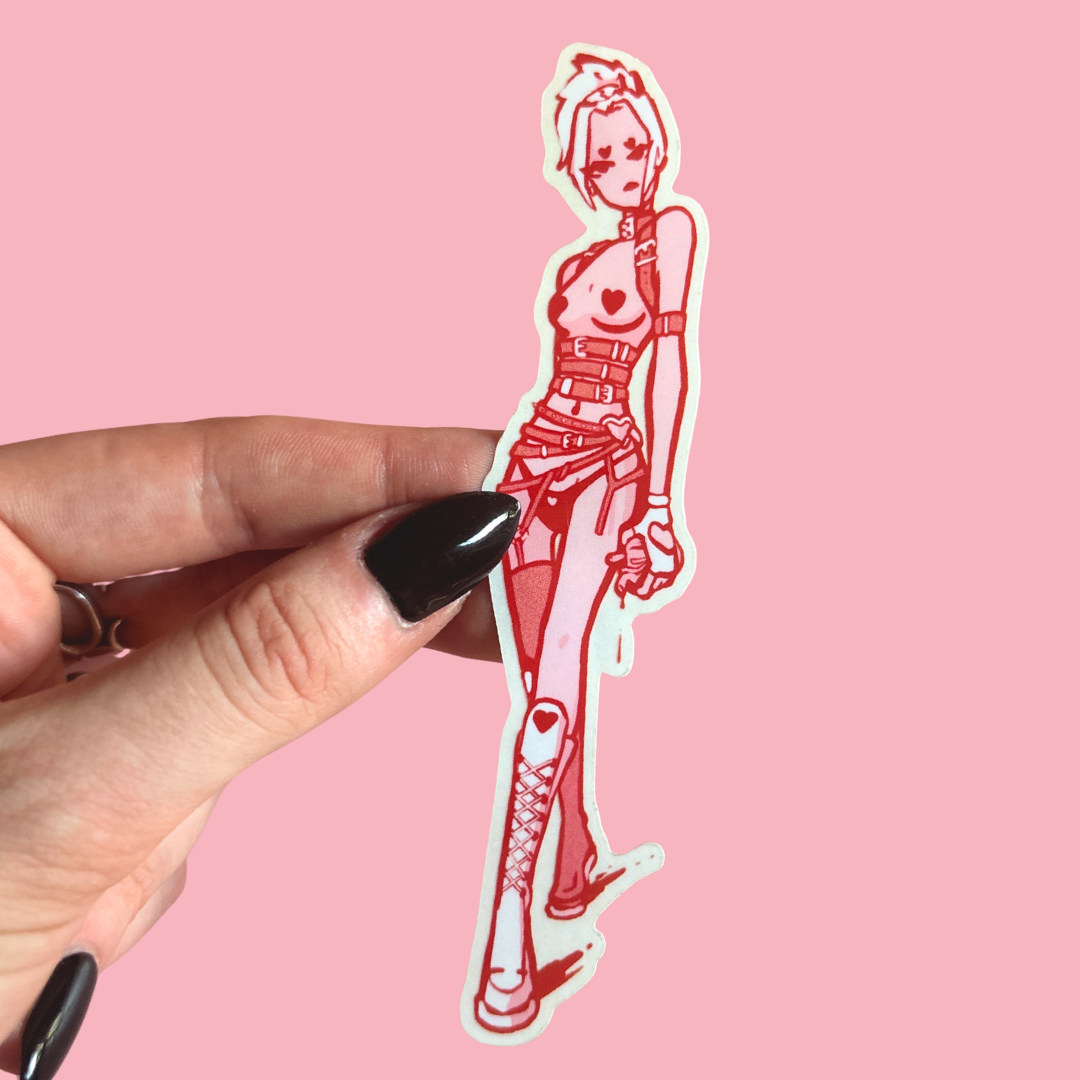 Hand holding a red and white sticker of a stylized character against a pink background