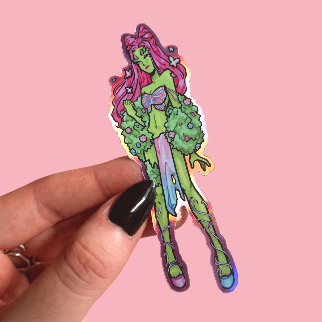 Colorful fairy sticker held by a hand on a pink background