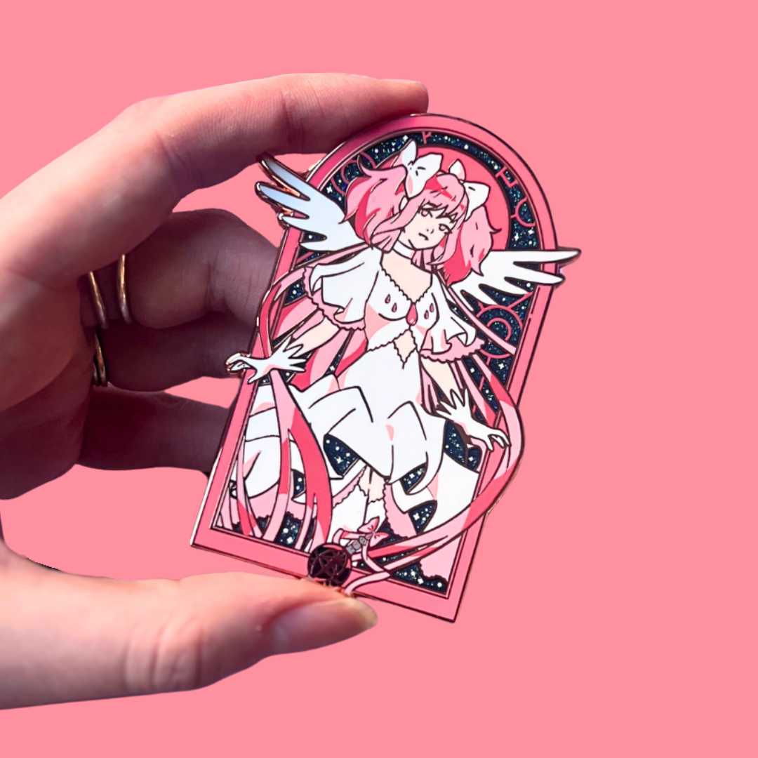 Hand holding a pin with an anime-style character on a pink background
