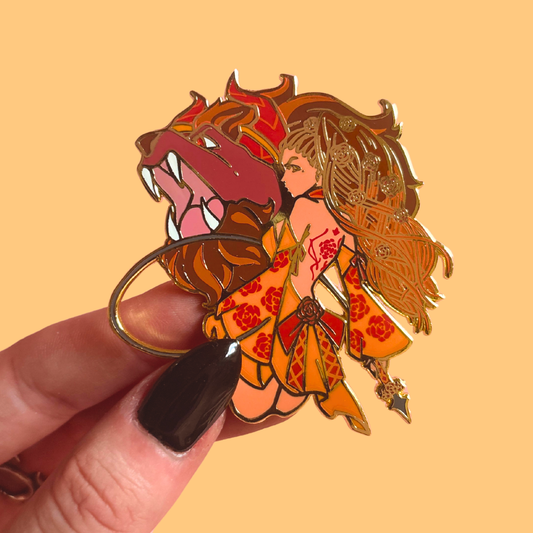 Pin with a stylized illustration of a woman and a lion on a beige background