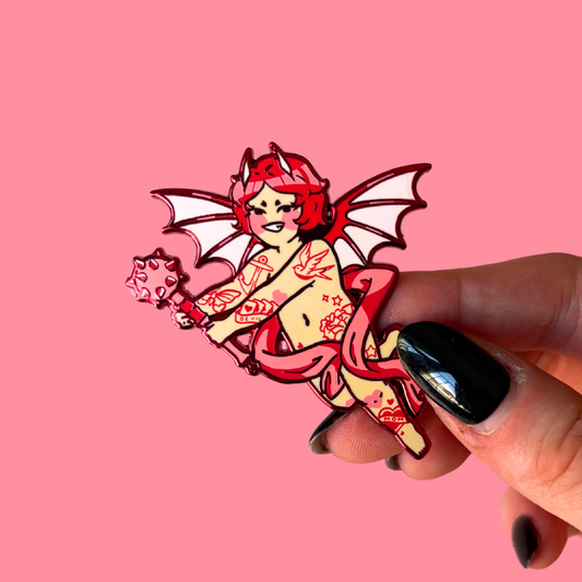 Pin with a design of a tattooed cherub holding a mace on a pink background