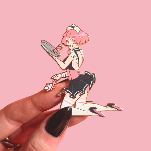 Enamel pin of an animated character dropping things held by a hand against a pink background