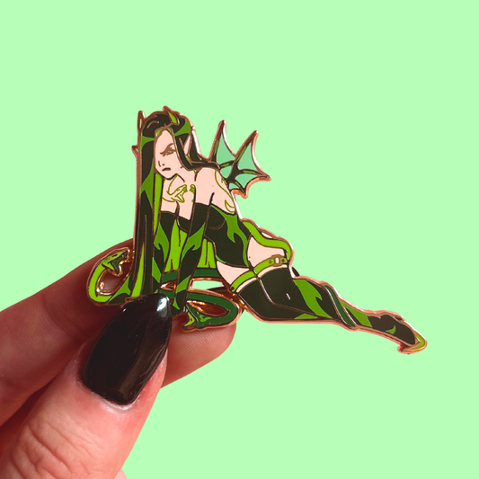Pin with a fantasy character design held by a hand against a light green background