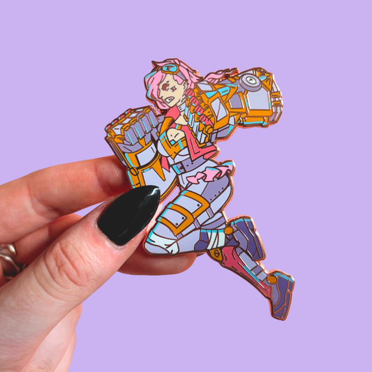 Colorful character pin held by a hand against a purple background