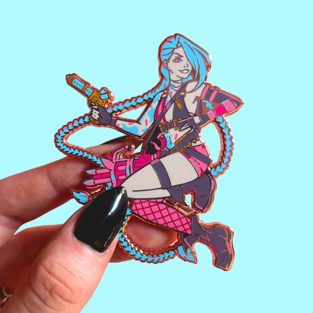 Colorful character pin held by a hand against a light blue background