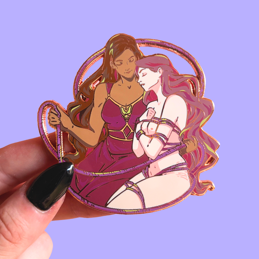 Pin of two women in warrior costumes and ropes held against a purple background