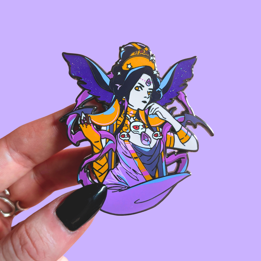 Hand holding a colorful pin against a purple background