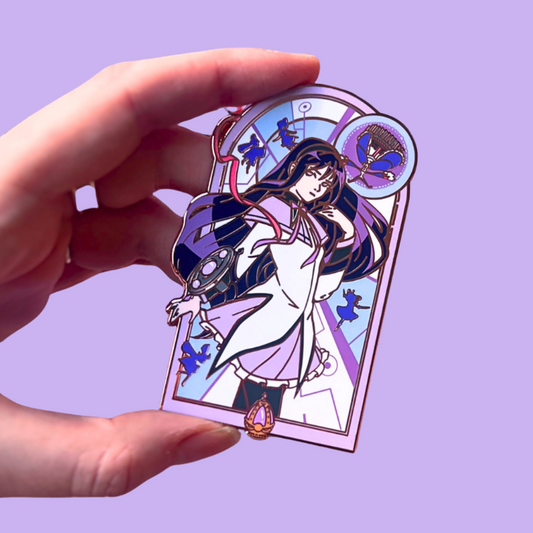 Hand holding a purple pin with an illustrated character design on a purple background