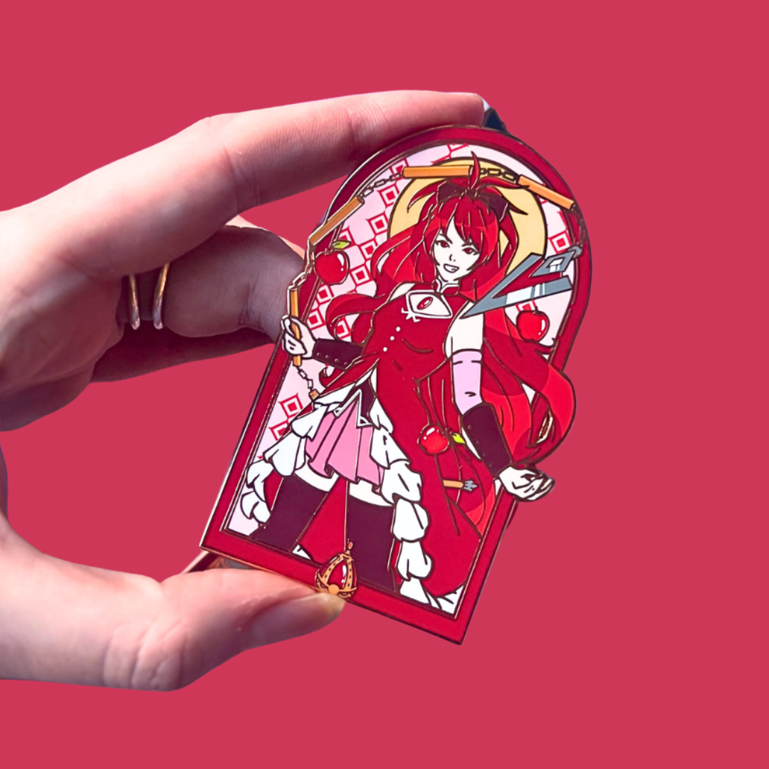 Red Anime-style character pin held by a hand against a red background