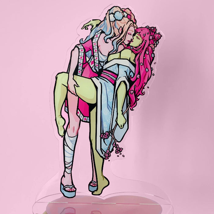 Colorful standee of two characters, one with blonde hair and one with pink hair in Japanese style clothes on a pink background