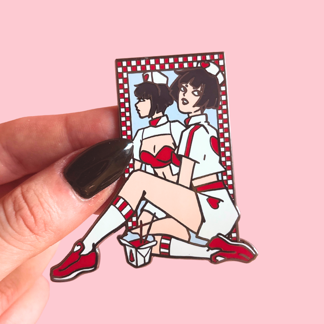 Enamel pin of an animated character in a checkered frame mirror held by a hand on a pink background
